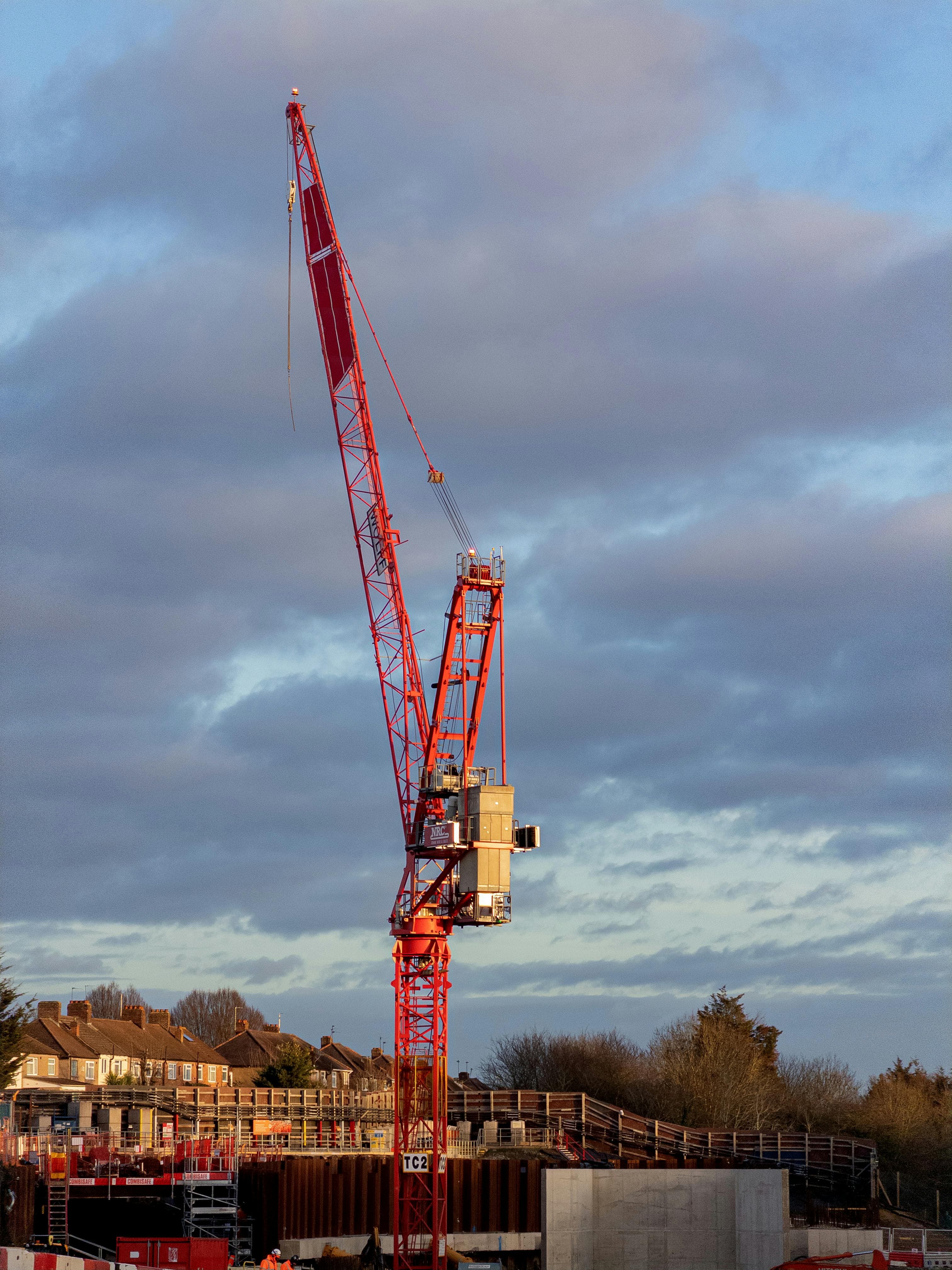 Red construction crane against overcast sky